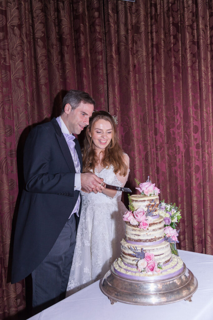 Wedding cake created by The Pastry Cake being cut by bride and groom