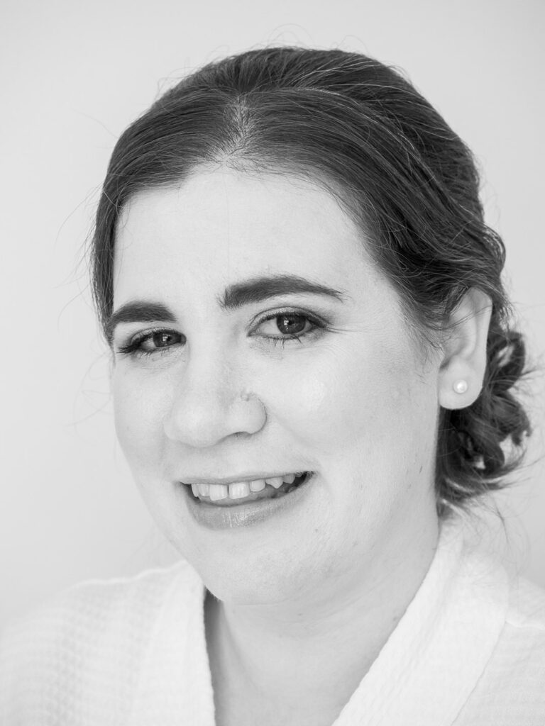 Monochrome portrait of smiling bride wearing white robe