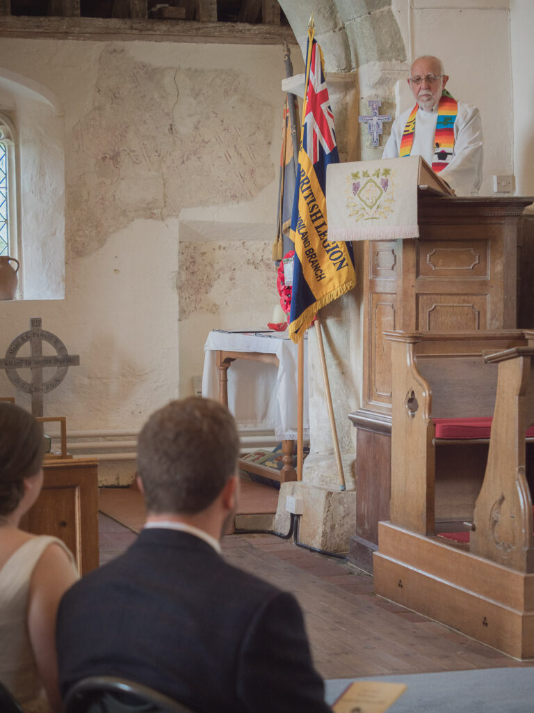 Vicar preaches from pulpit during classic English country church wedding