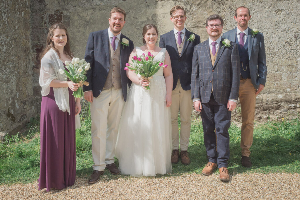 Bride groom, bridesmaid, best man and ushers after  classic English country church wedding