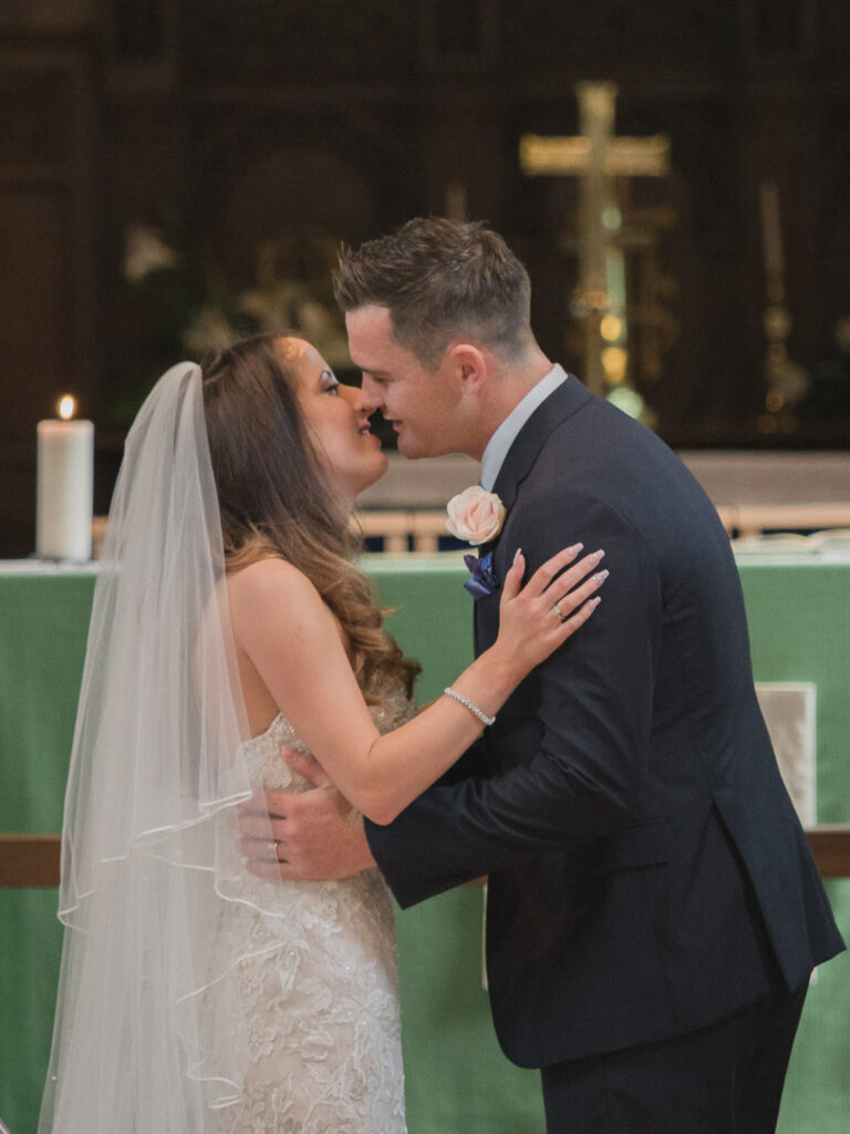 Newly-married couple about to kiss after taking marrieage voews in Portchester Church