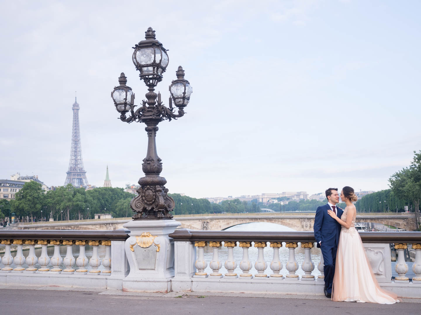 Elegant couple in wedding dress on the Pont Aleandre III with the Eiffel Tower in the background