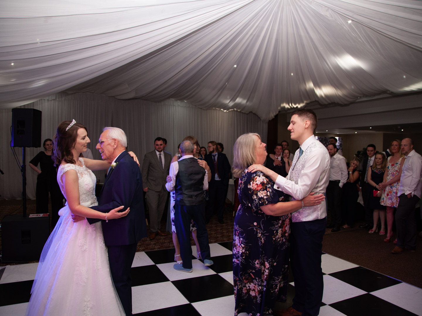 Norton Park wedding photographer Bride dances with her father while groom dances with his mother on checkerboard floor