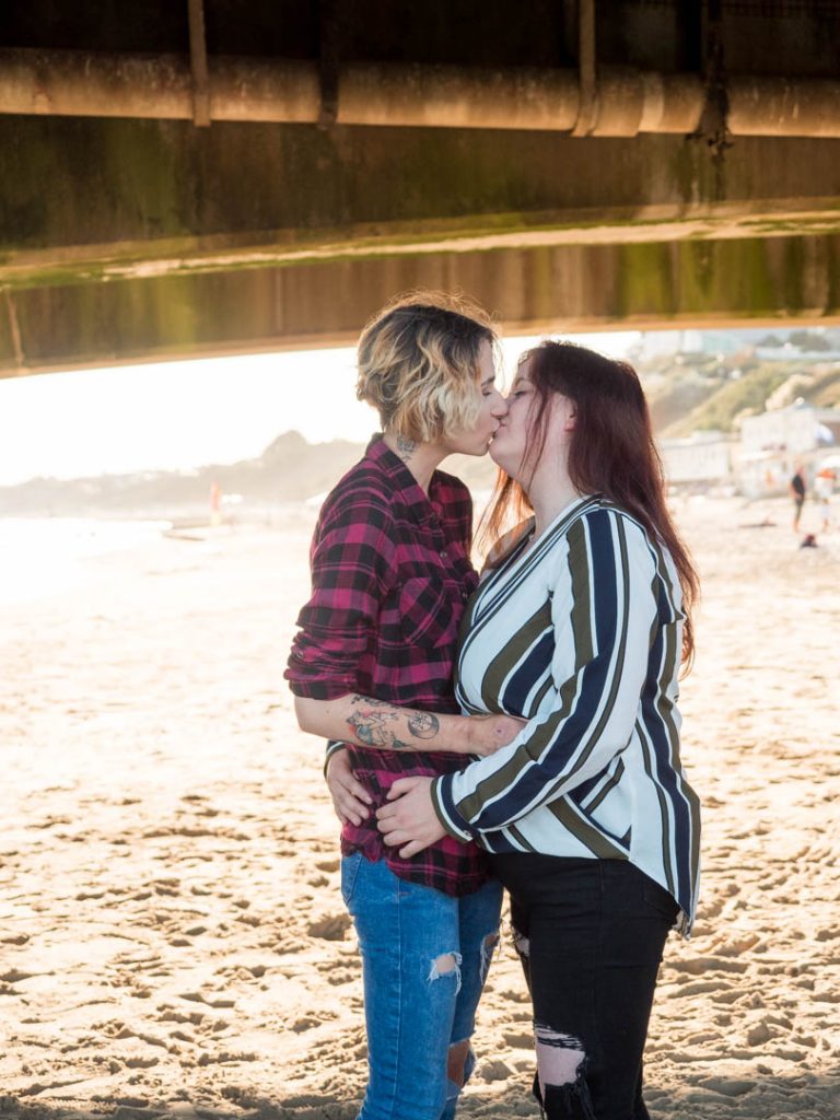 Lesbian couple kissing beneath Bournemouth Pier