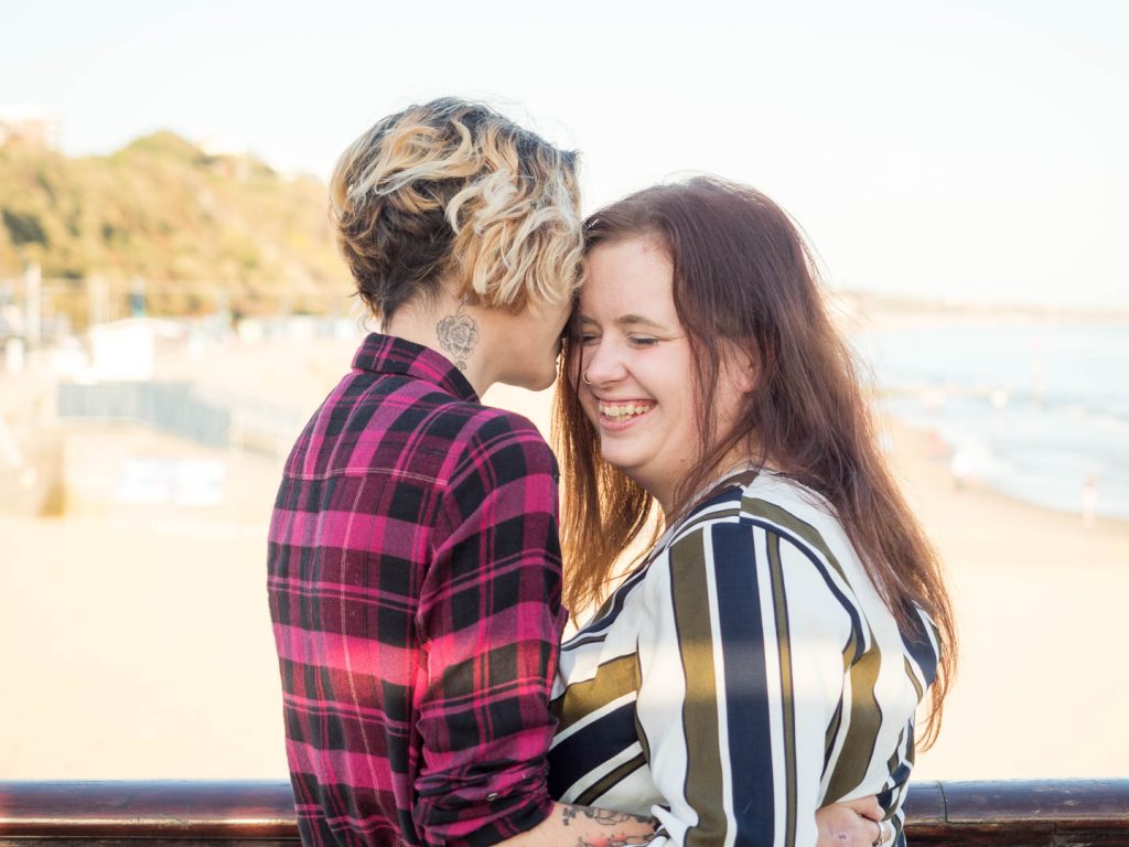 Lesbian couple embracing on Bournemouth Pier