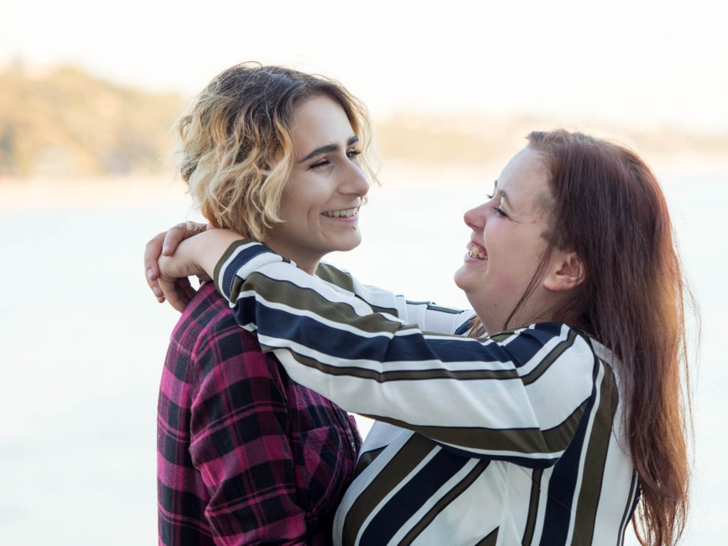 Lesbian couple embracing on Bournemouth Pier