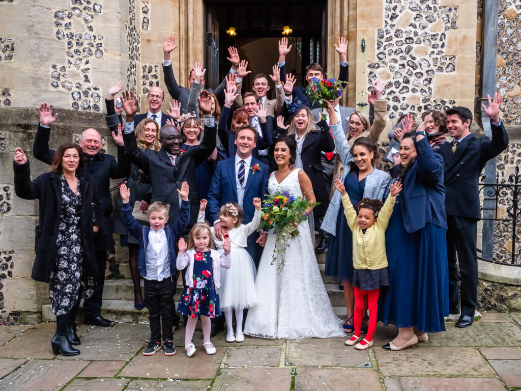 Wedding party waves for the camera outside Winchester Registry Office