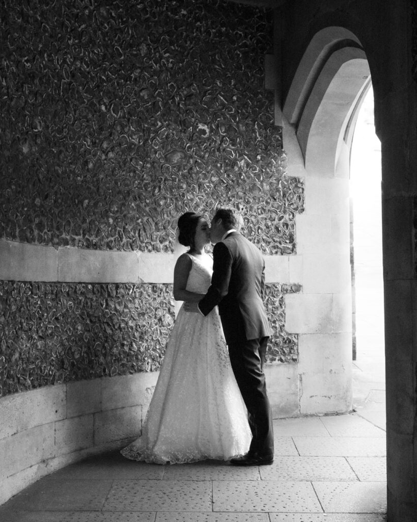 Bride and groom kiss beneath the arch of Winchester's Westgate