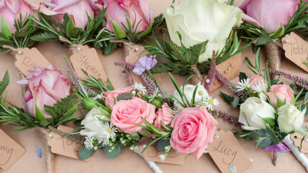 Wedding buttonholes – white, pink and purple roses – created by Willow Florist
