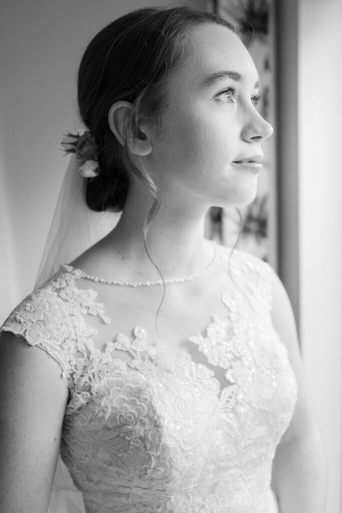 Classic monochrome window-lit image of Michaela in her wedding dress