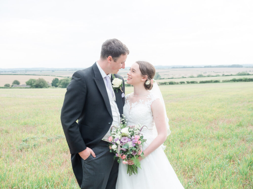 Michaela and Rupert gaze adoringly at each other in a field