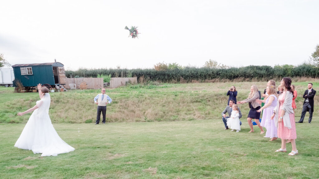 Bridal bouquet in mid-flight as women compete to catch it