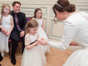 Bride gives flower girl an iced cup cake