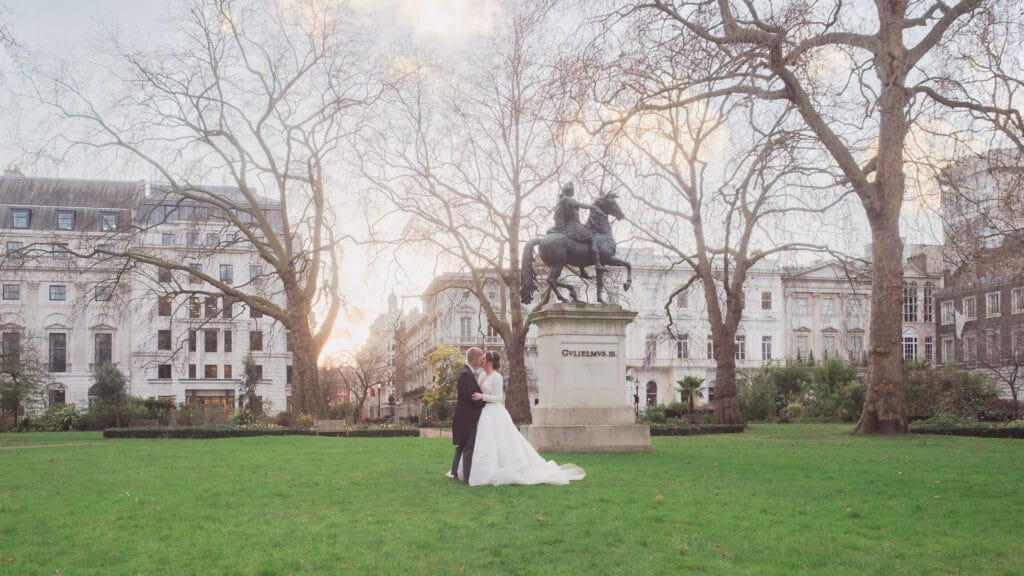 Bride and groom kiss in St. James's Square, London