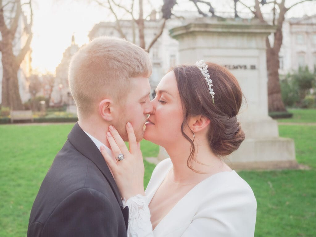 Bride and groom kiss in St. James's Square, London