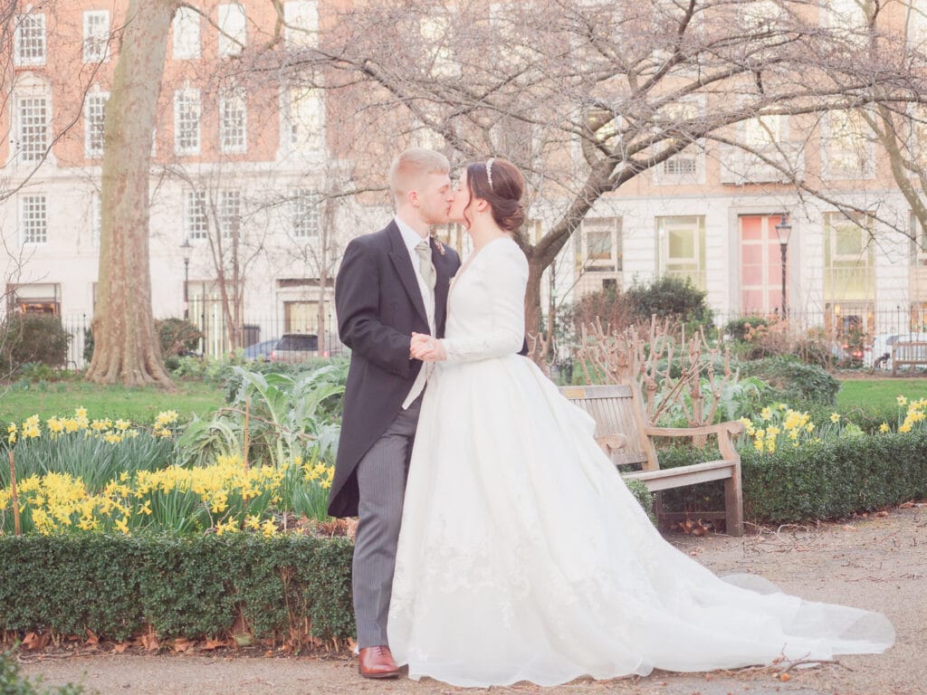 Bride and groom kiss in St. James's Square, London