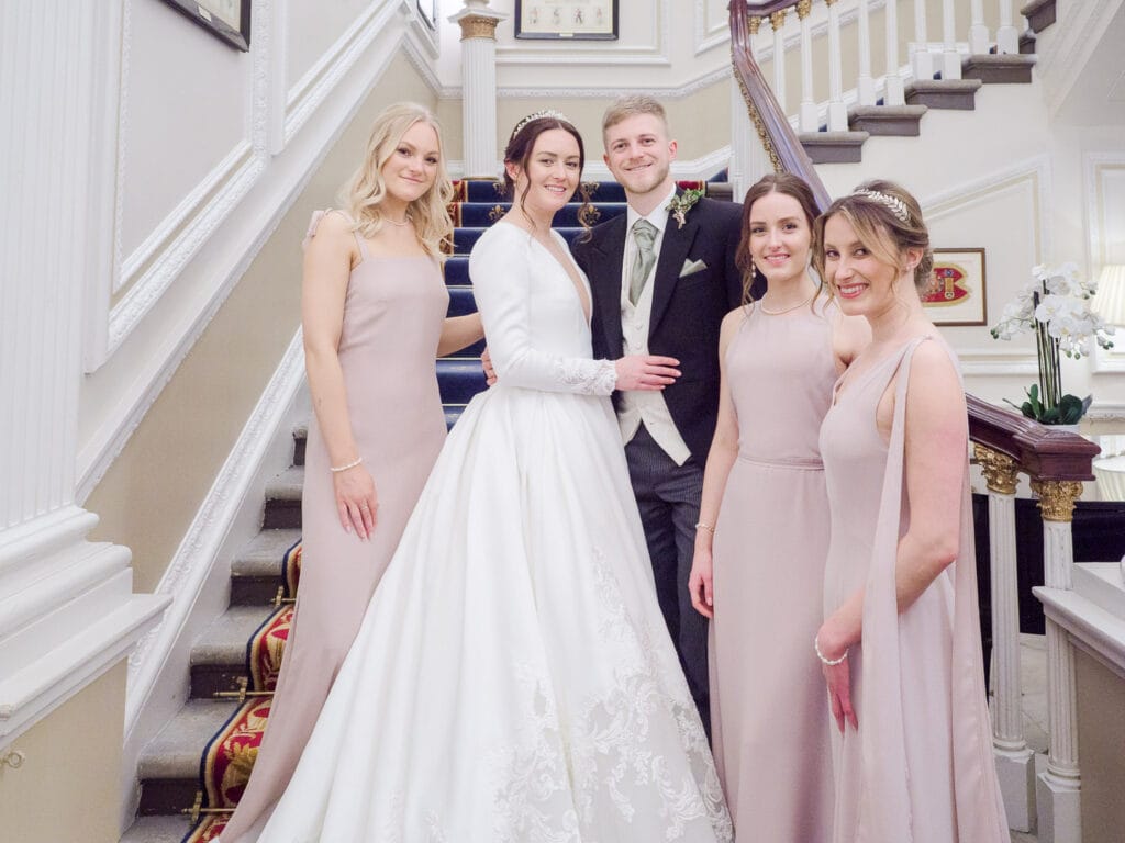 Bride, groom and bridesmaids on the stairs at the Naval and Military Club