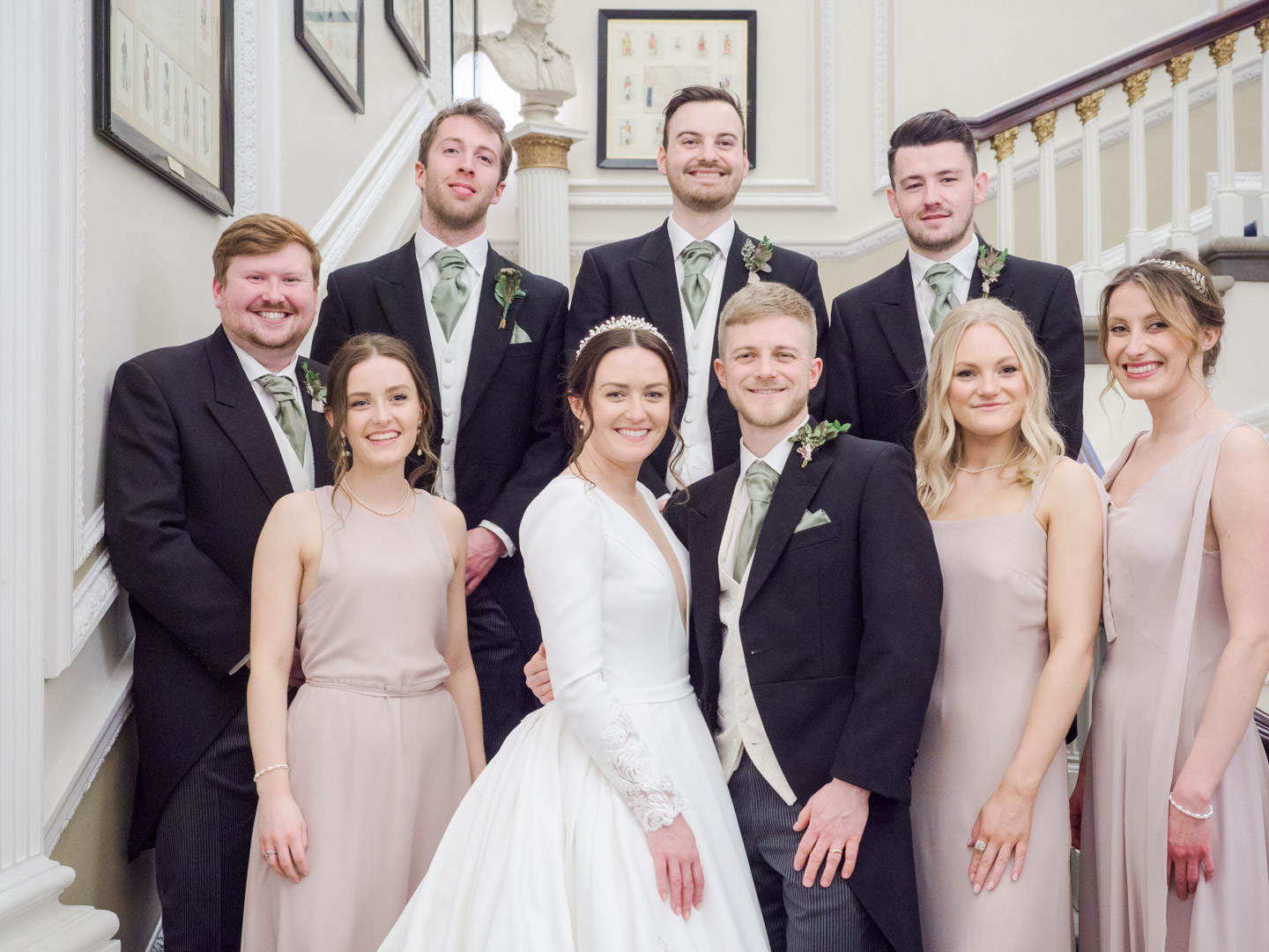 Bride, groom, bridesmaids and ushers on the stairs at the Naval and Military Club