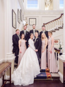 Bride, groom, bridesmaids and ushers on the stairs at the Naval and Military Club