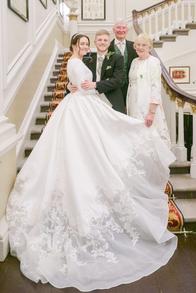 Bride, groom and grandparents on the stairs at the Naval and Military Club