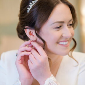 Bride fastens an earring before her wedding