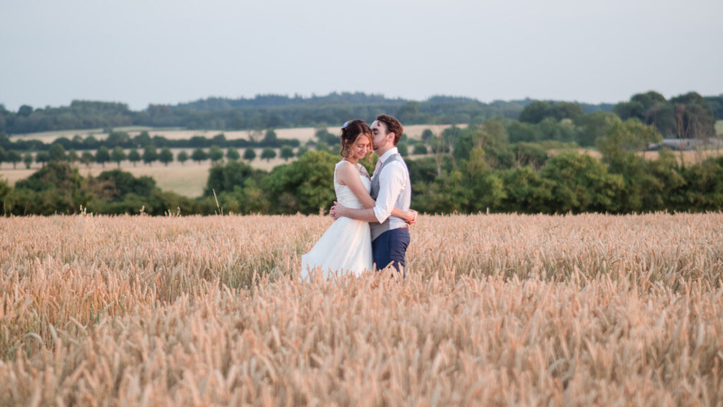 Newlyweds embrace in cornfield