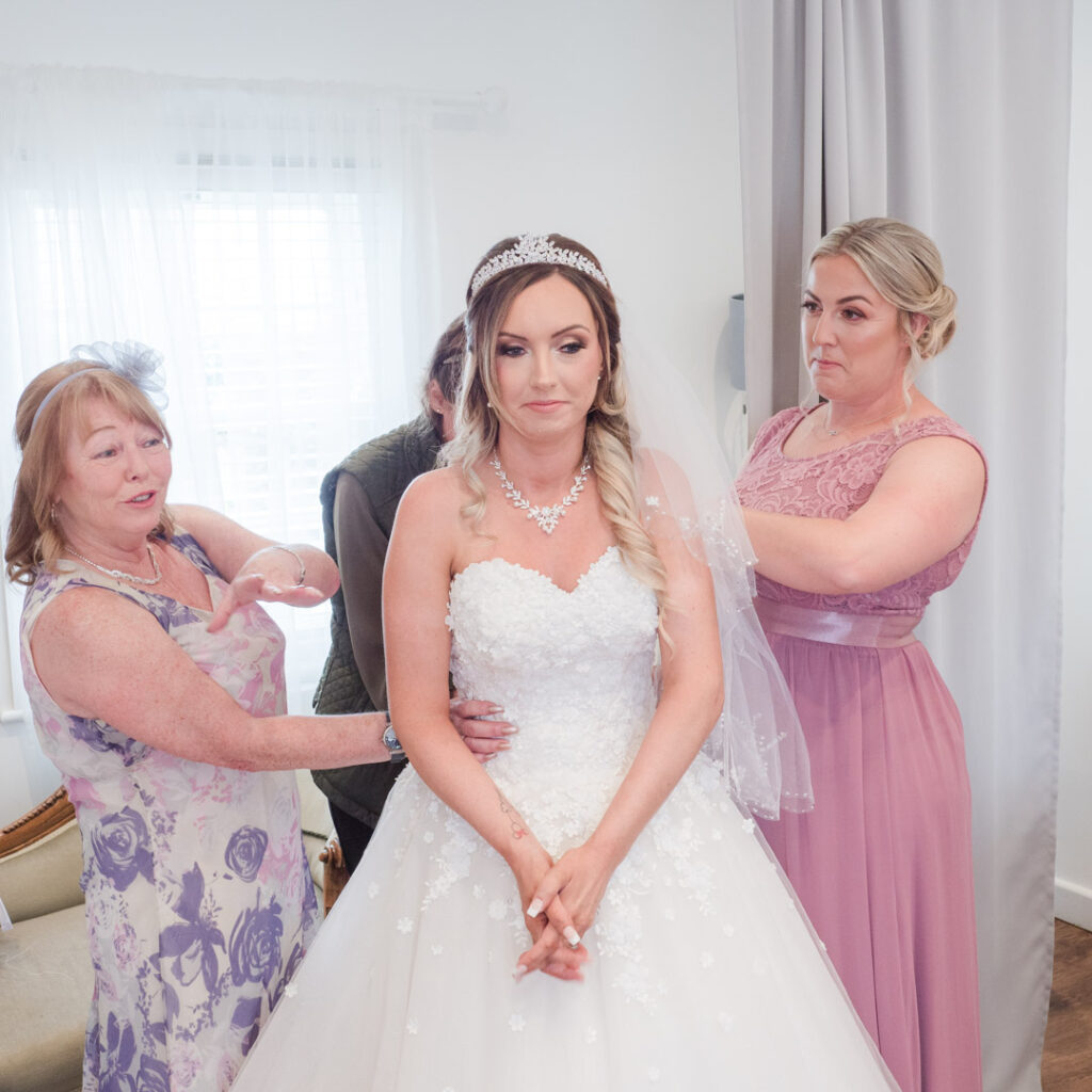 Lacing bride into her wedding dress