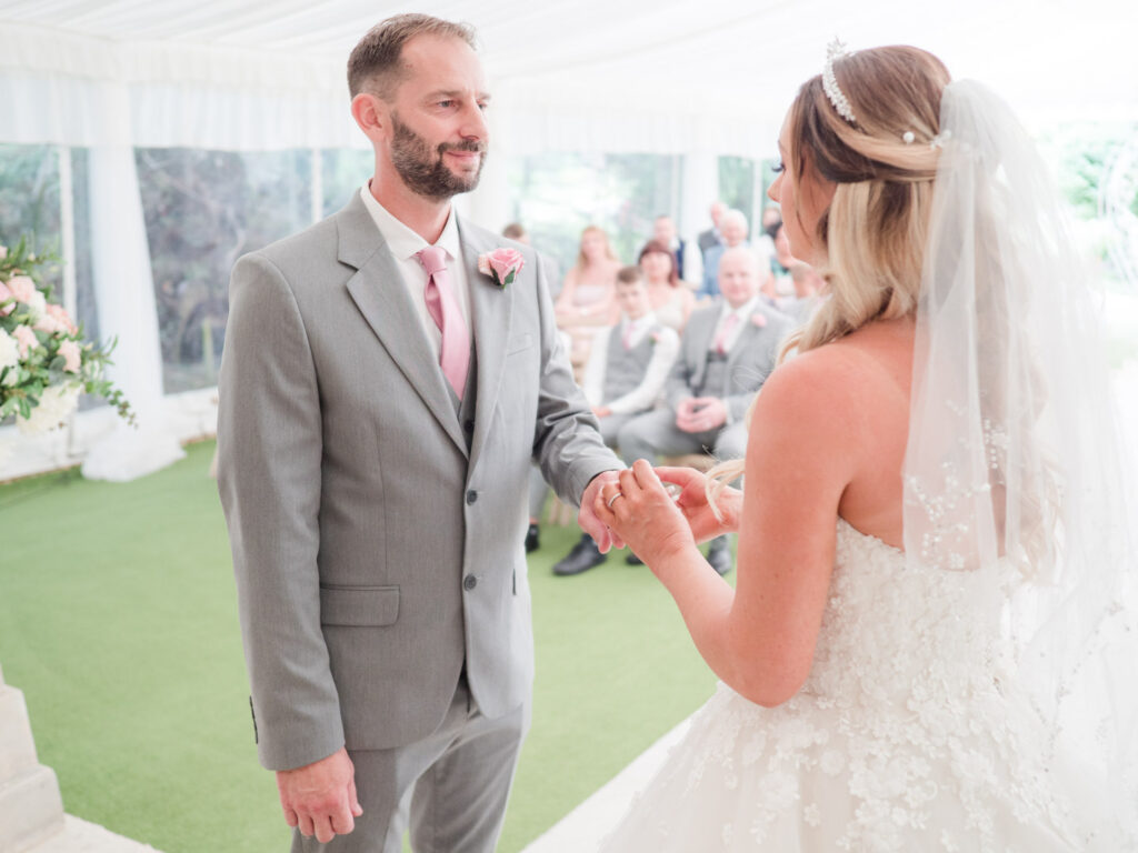 Bride places ring on groom's finger