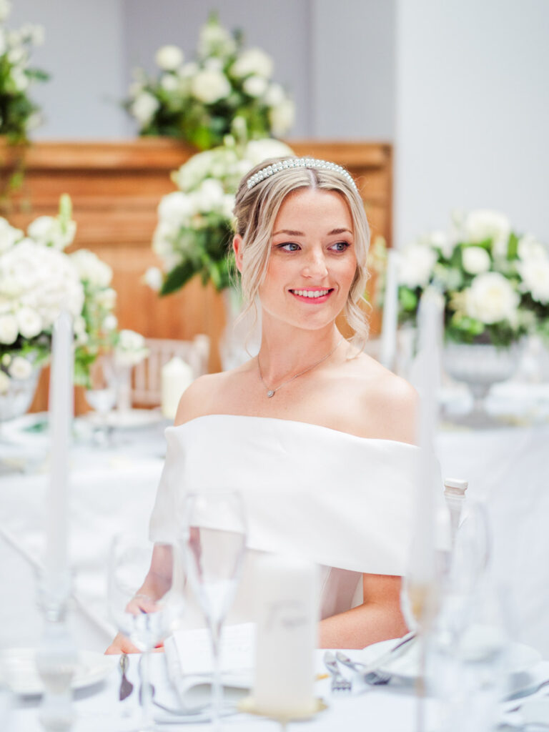 Bride seated at a table laid for her wedding breakfast