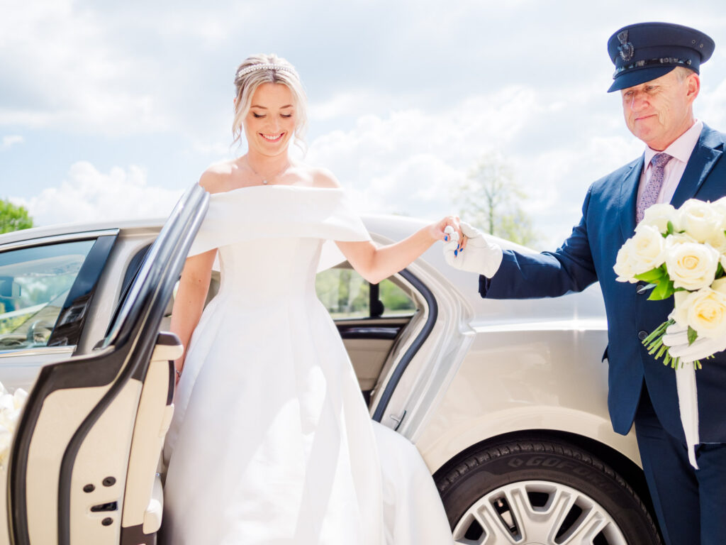 Chauffeur helps bride out of her wedding limousine