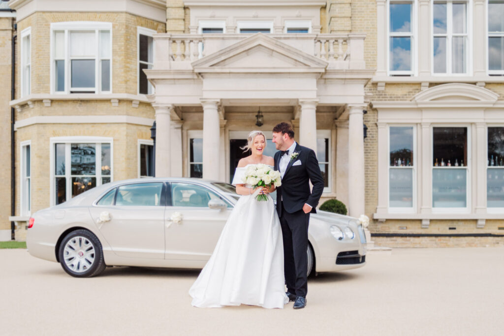 Bride, groom and their wedding limousine outside The Mansion at Coldeast