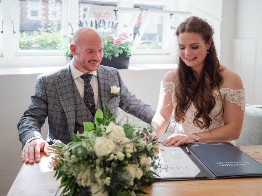 Bride signs the register during wedding ceremony