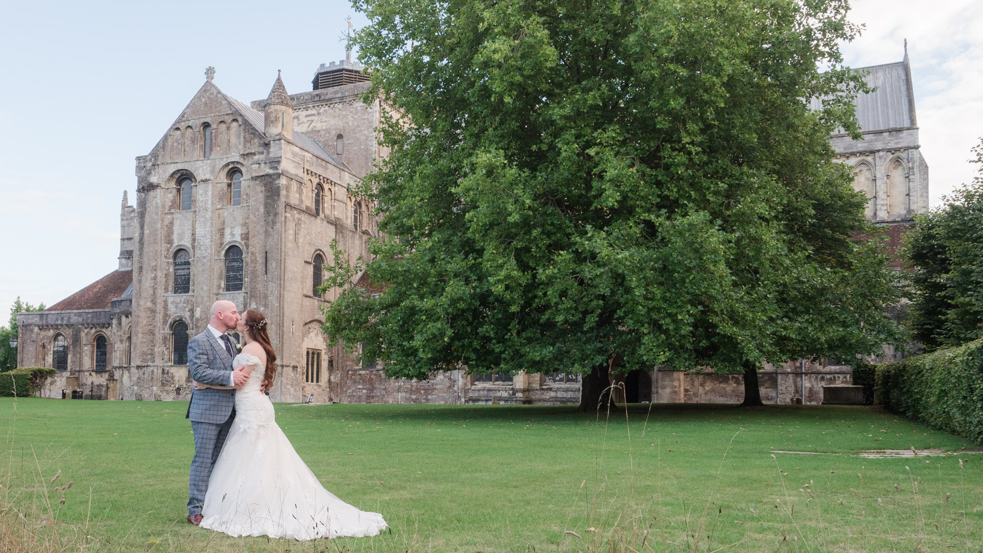 Couple kiss on the lawn outside Romsey Abbey