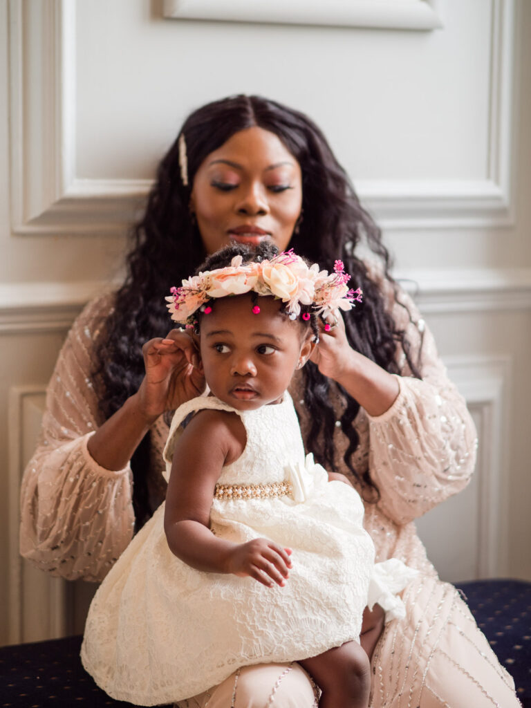 Bridesmaid adjusts her toddler daughter's headdress