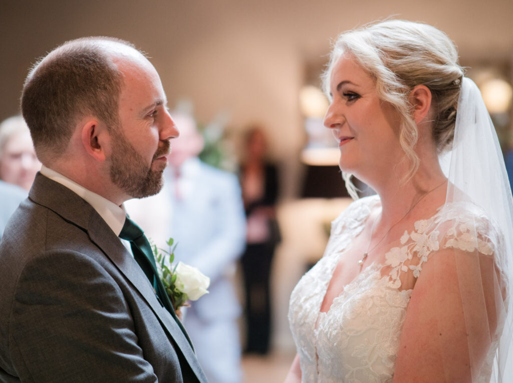 Couple face each other as they begin thier wedding vows