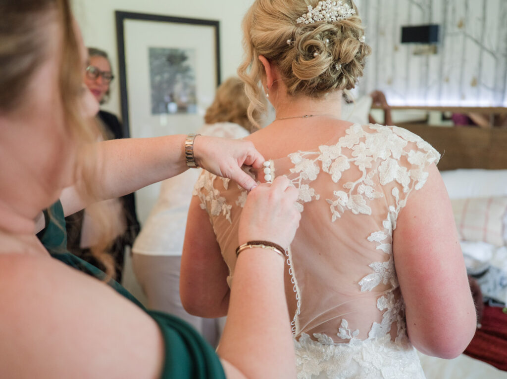 Buttoning up bride's wedding dress