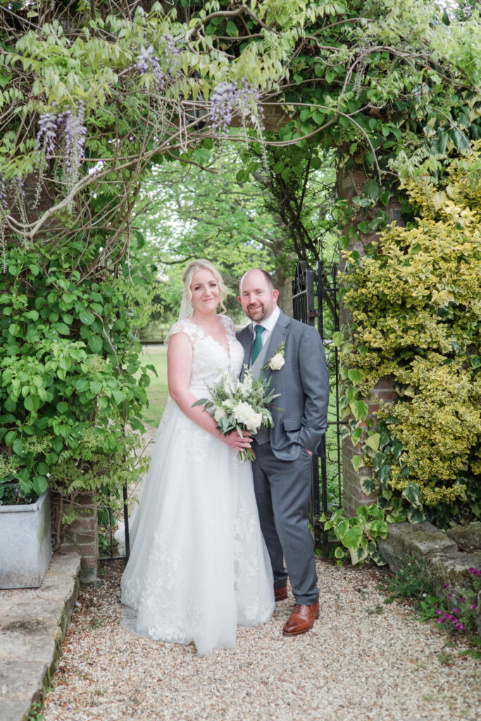 Bride and groom in a gateway at Carey's Manor