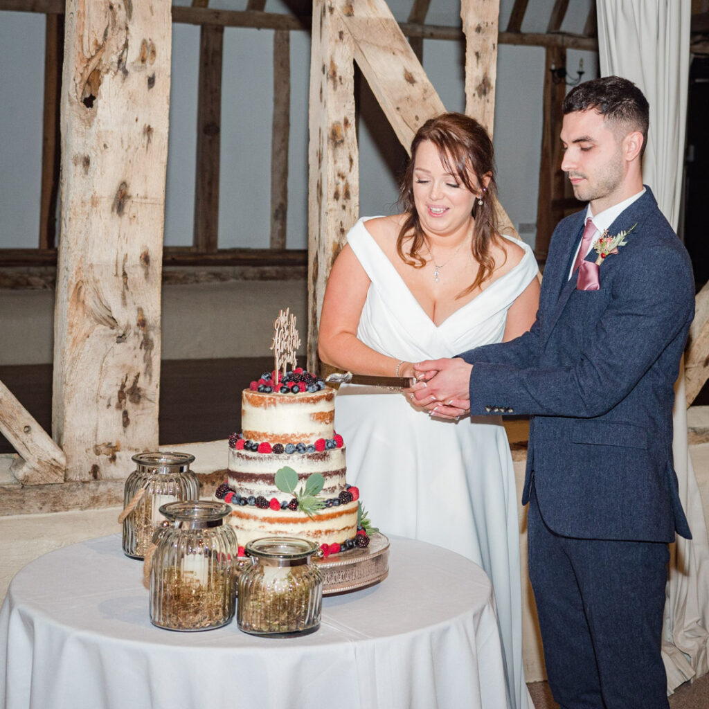 Bride and groom cut their cake at Clock Barn