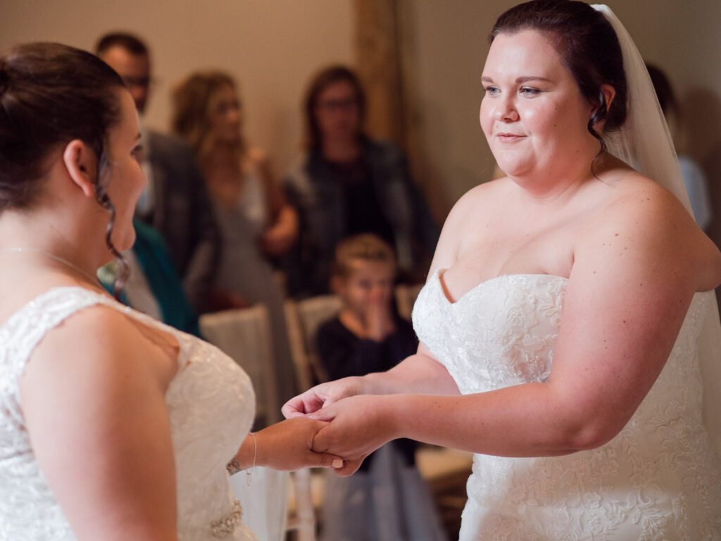 Bride places ring on her bride's finger