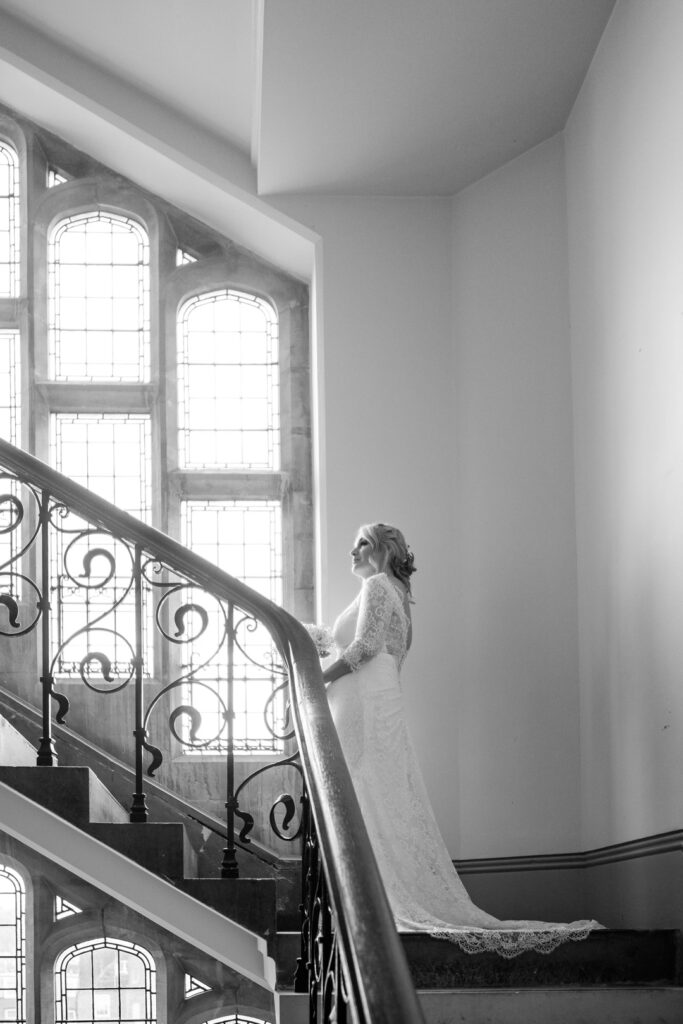 Bride climbs a flight of ornate stairs