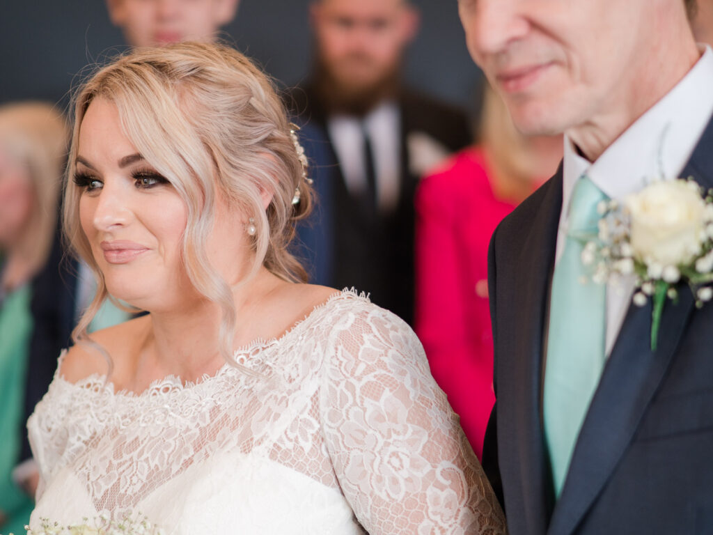 Bride smiles at her husband as she walks up the aisle