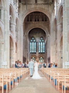 Bride and her father walk up the aisle in Romsey Abbey
