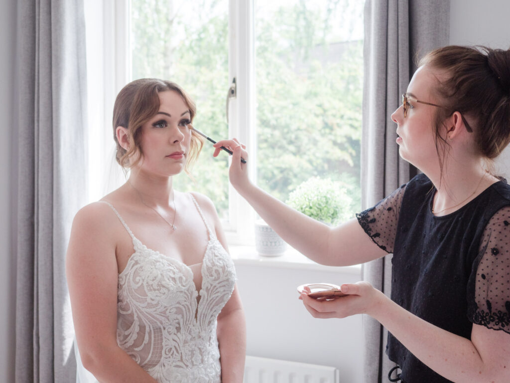 Make-up artist touches up bride's eyeliner