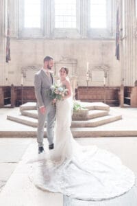 Bride and groom in front of the font in Romsey Abbey