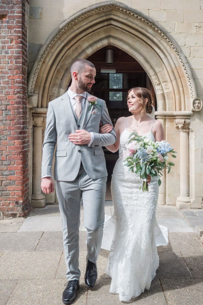 Bride and groom walk out of Romsey Abbey