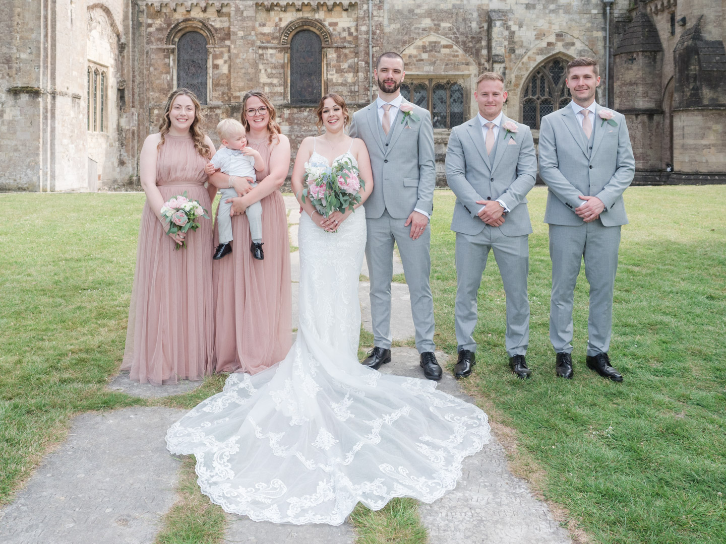 Bride, groom, bridesmaids and groomsmen outside Romsey Abbey