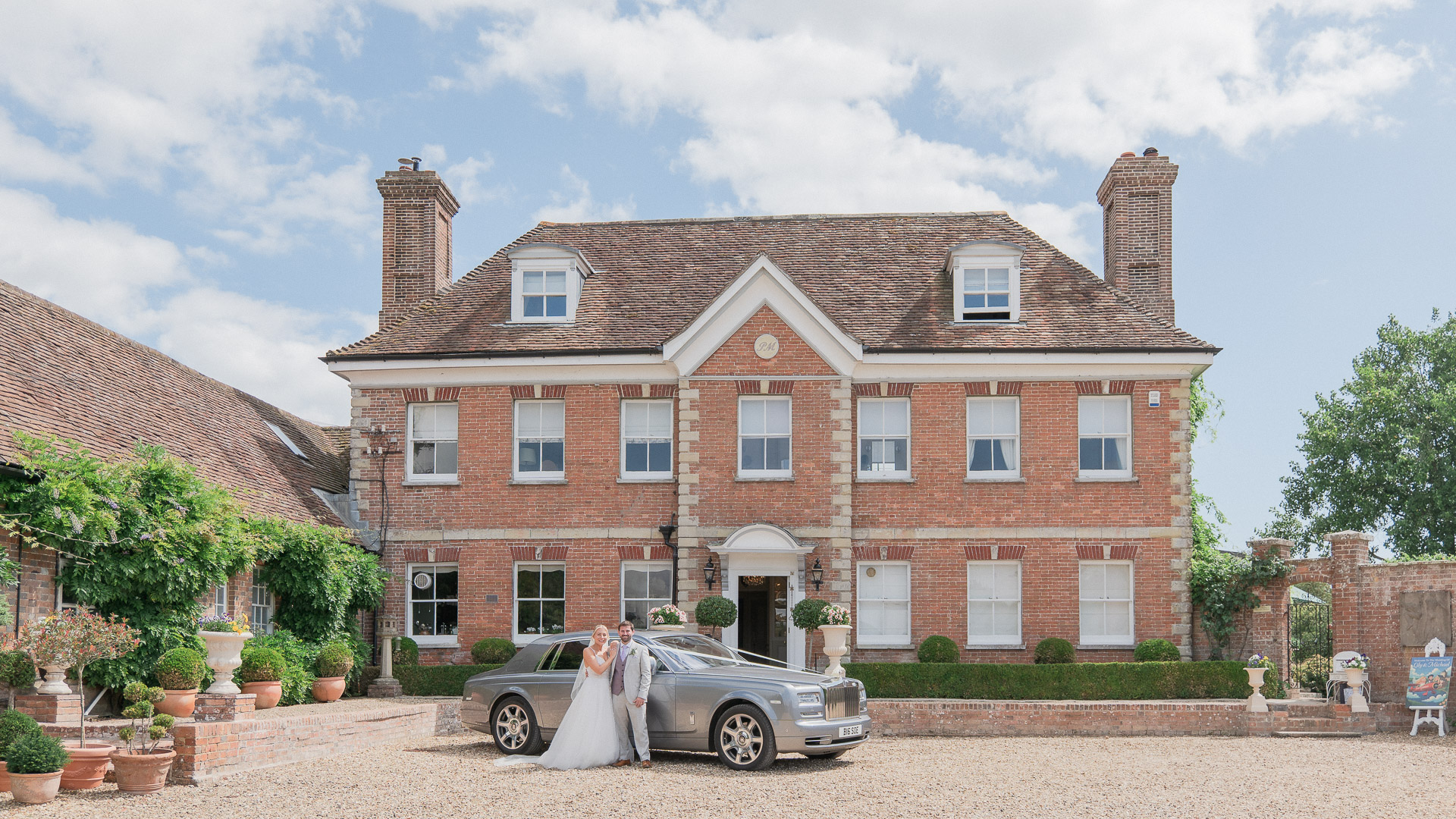 Bride and groom with Rolls Royce outside Parley Manor