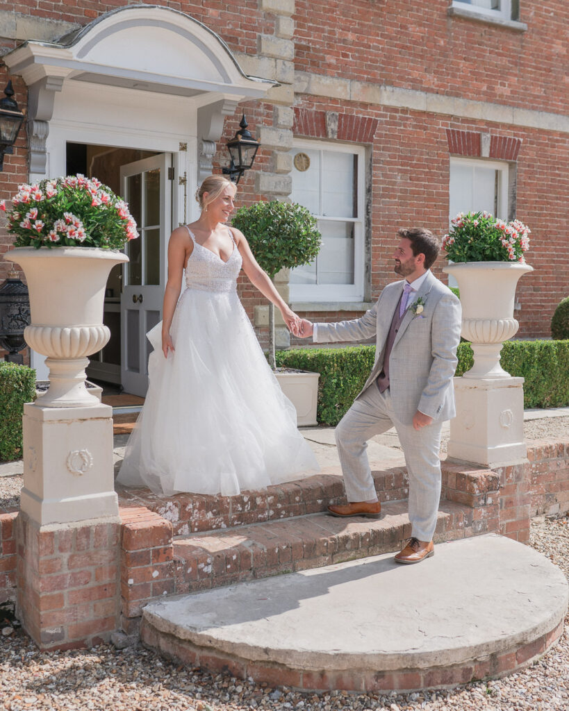 Bride and groom on the steps outside Parley Manor