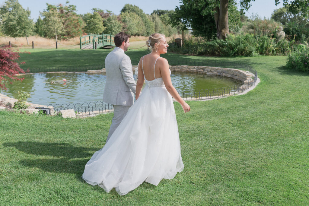 Bride and groom walk in the garden outside Parley Manor