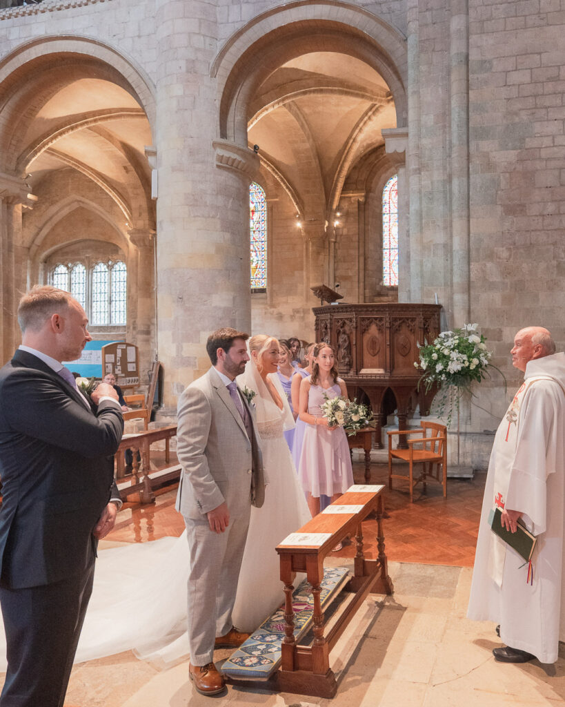 Vicar adresses the bride, groom and congregation at start of wedding service in Romsey Abbey